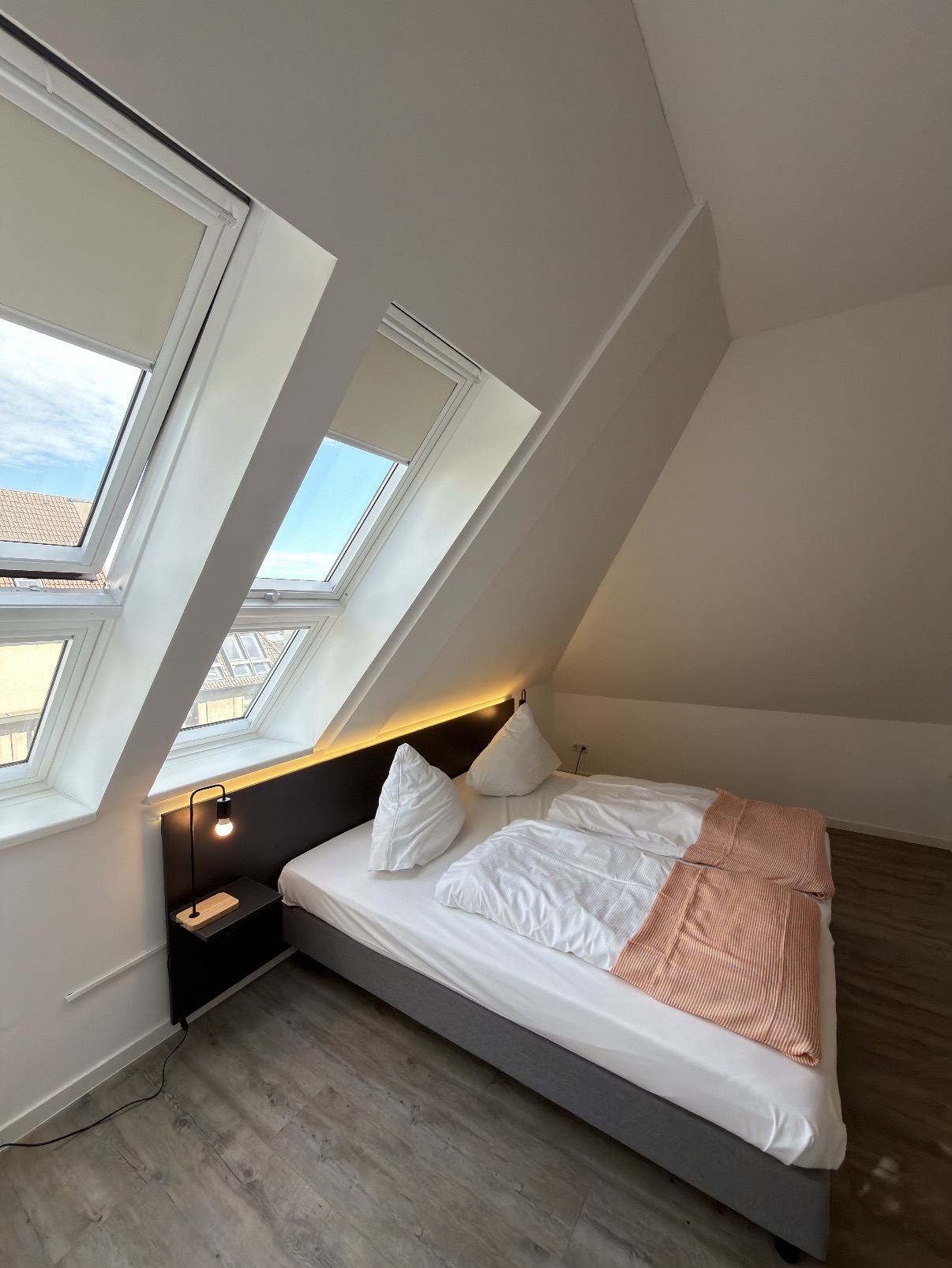 Doppelbett neben den großen Dachfenstern