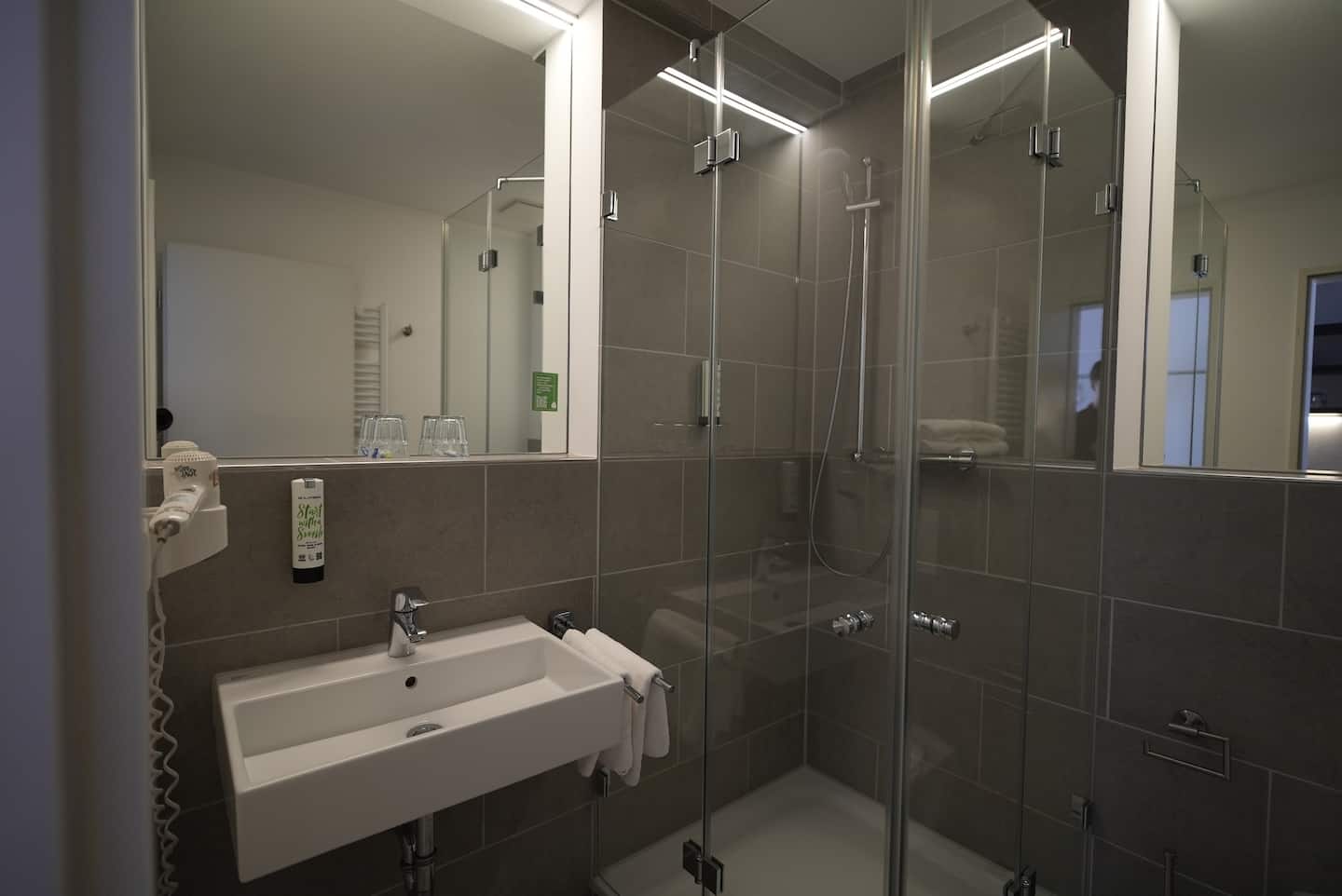 Bad mit Waschbecken und verglaster Dusche