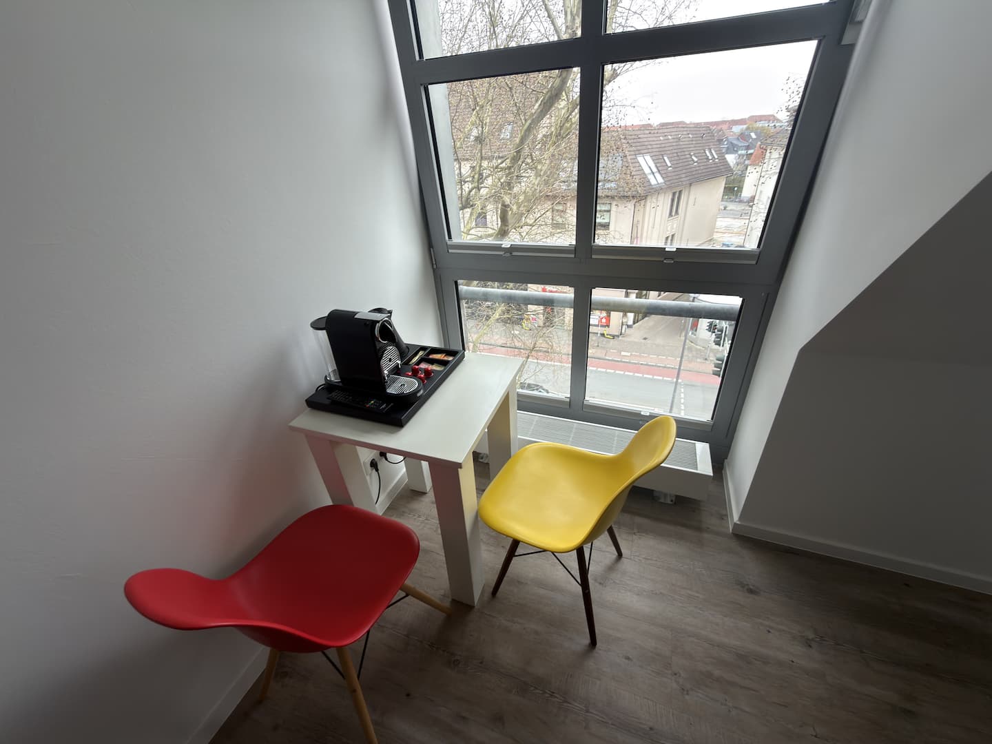 Arbeitsplatz mit rotem und gelbem Stuhl am Fenster