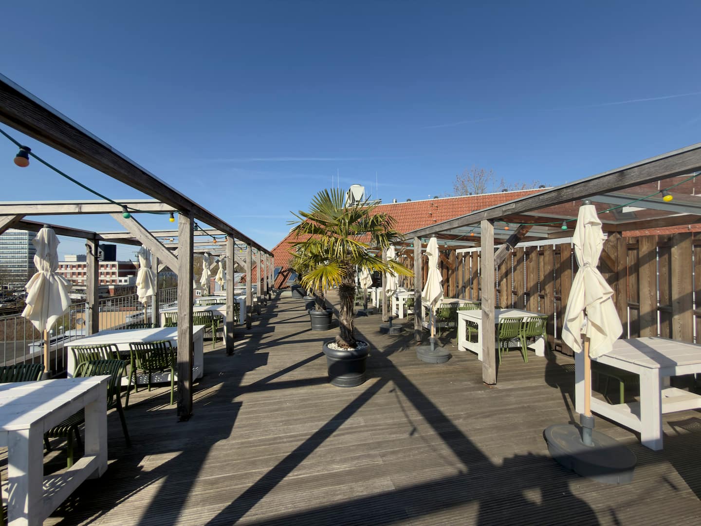 Lange Dachterrasse mit Sitzgruppen und Sonnenschirmen