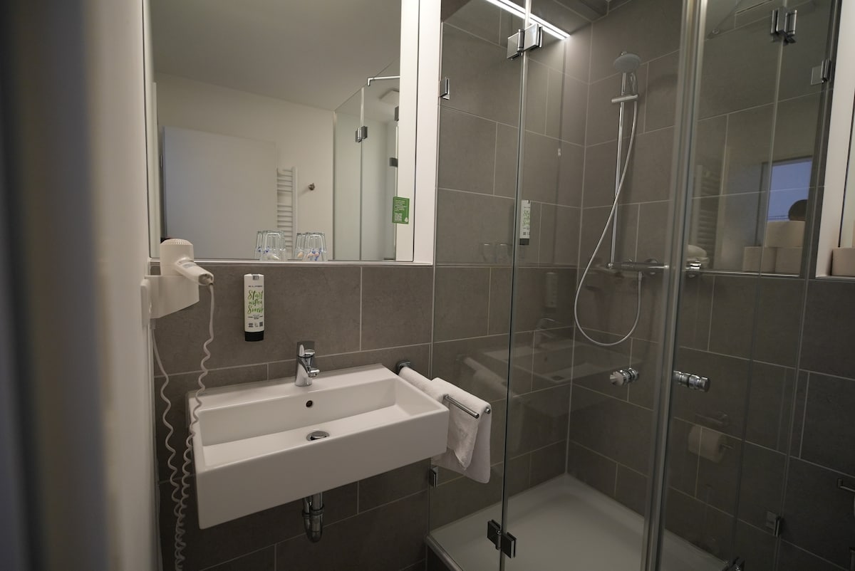 Duschbad mit Waschbecken und Glaskabine