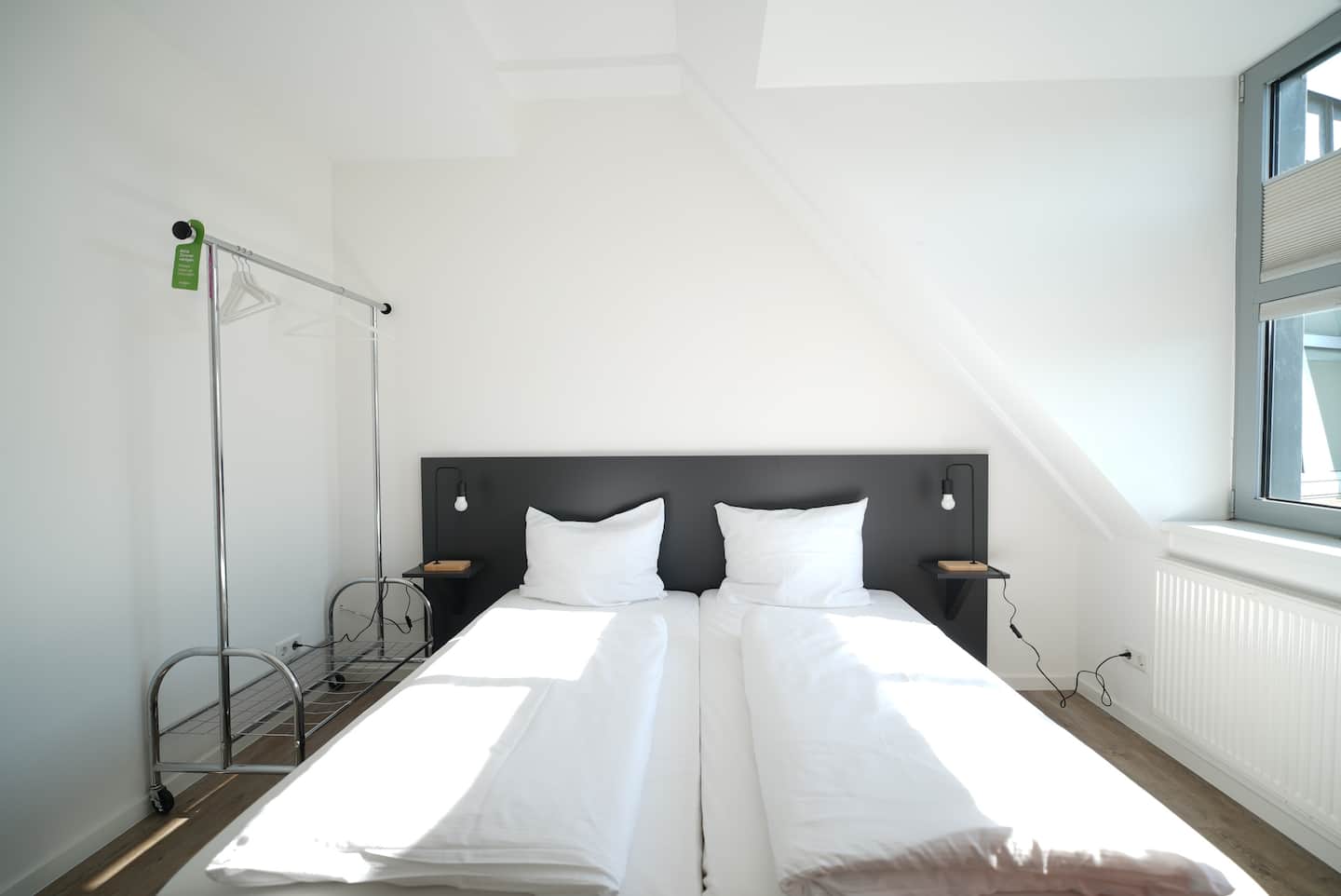 Bett mit frisch bezogener Bettwäsche unter der Dachschräge