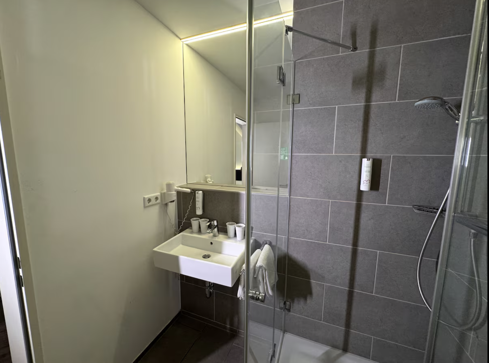 Waschbecken mit Spiegel im Duschbad