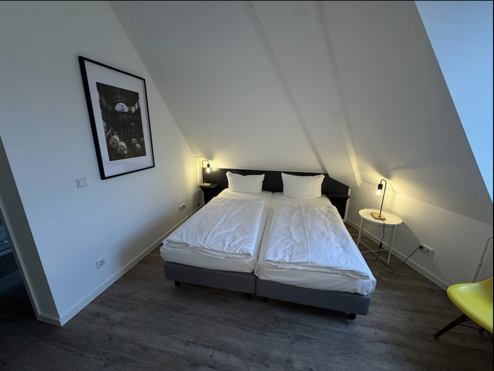 Schlafbereich mit gemachtem Bett und Blick zum Fenster