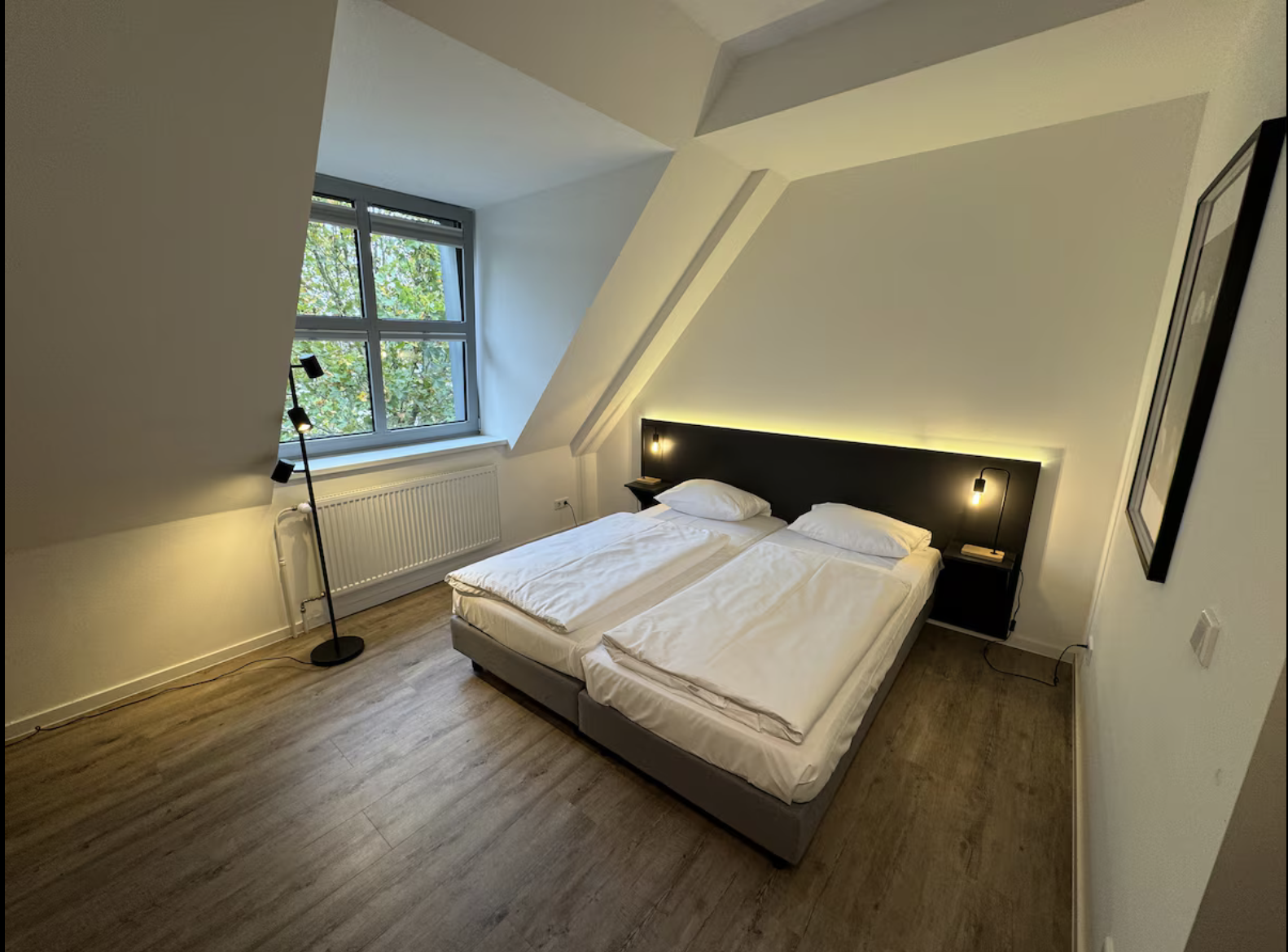 Schlafbereich mit Doppelbett und heller Wandfarbe