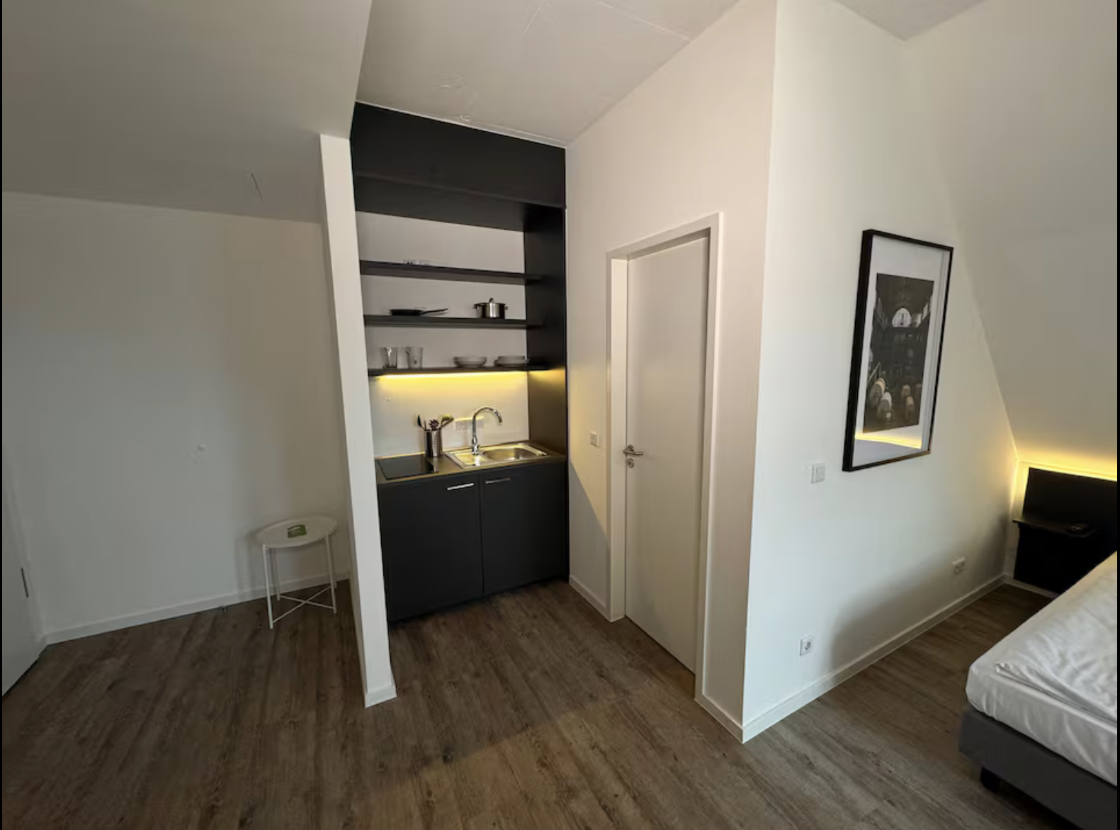 Offener Wohnbereich mit Kleiderstange, TV und Holzboden