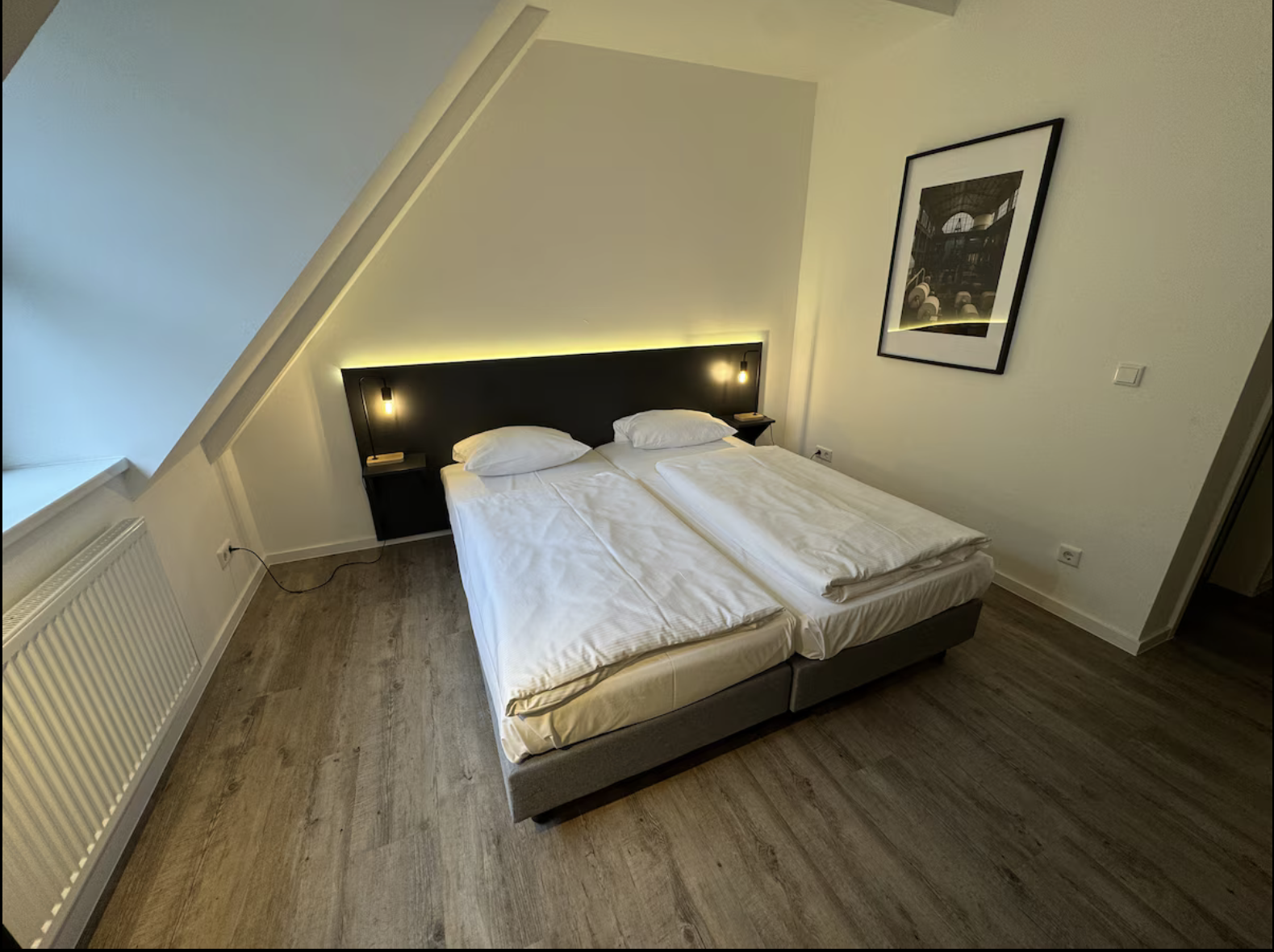 Schlafbereich mit breitem Bett und Nachttischleuchten