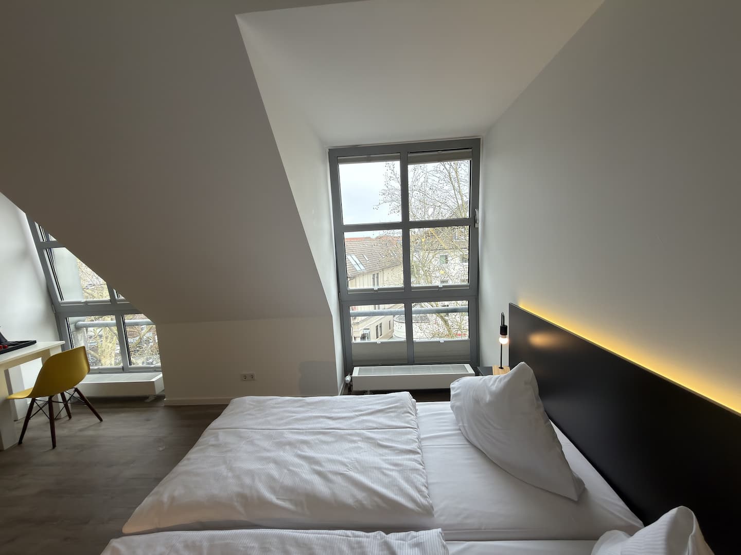 Blick vom Bett zum Fenster mit Schreibtisch