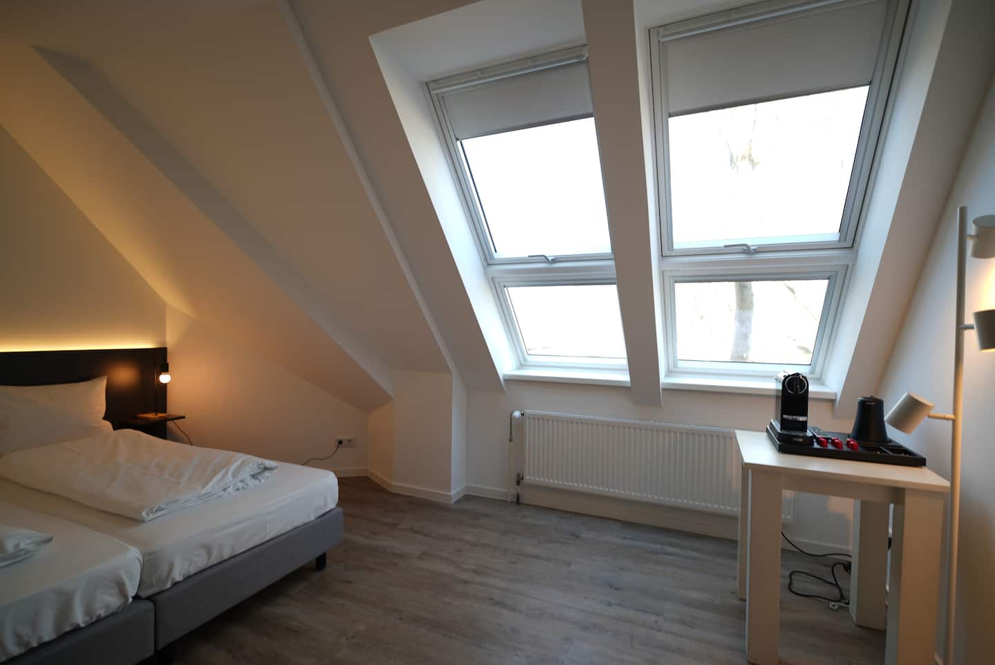 Bett unter großen Dachfenstern mit Tageslicht