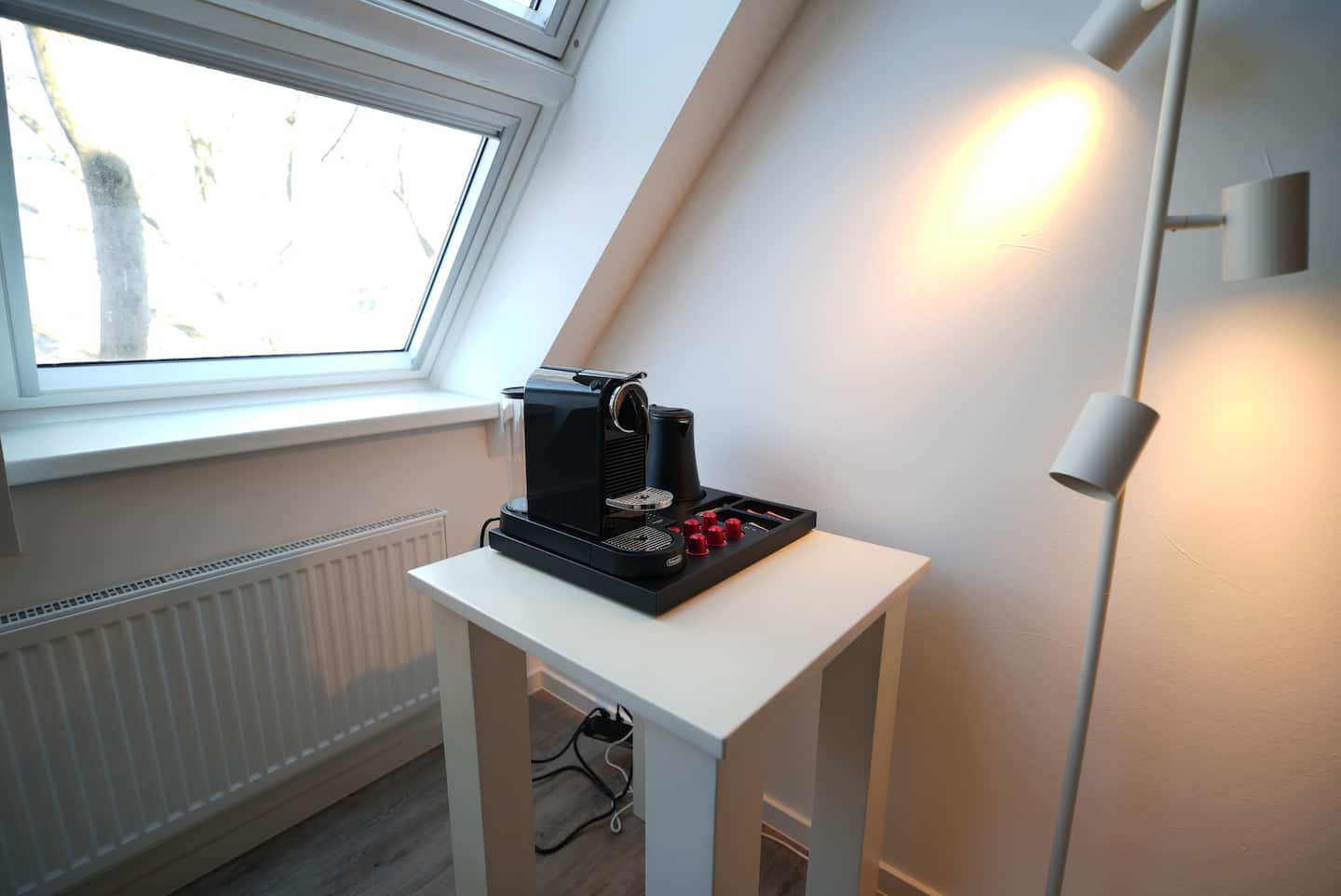 Schreibtisch mit Kaffeemaschine unter dem Dachfenster