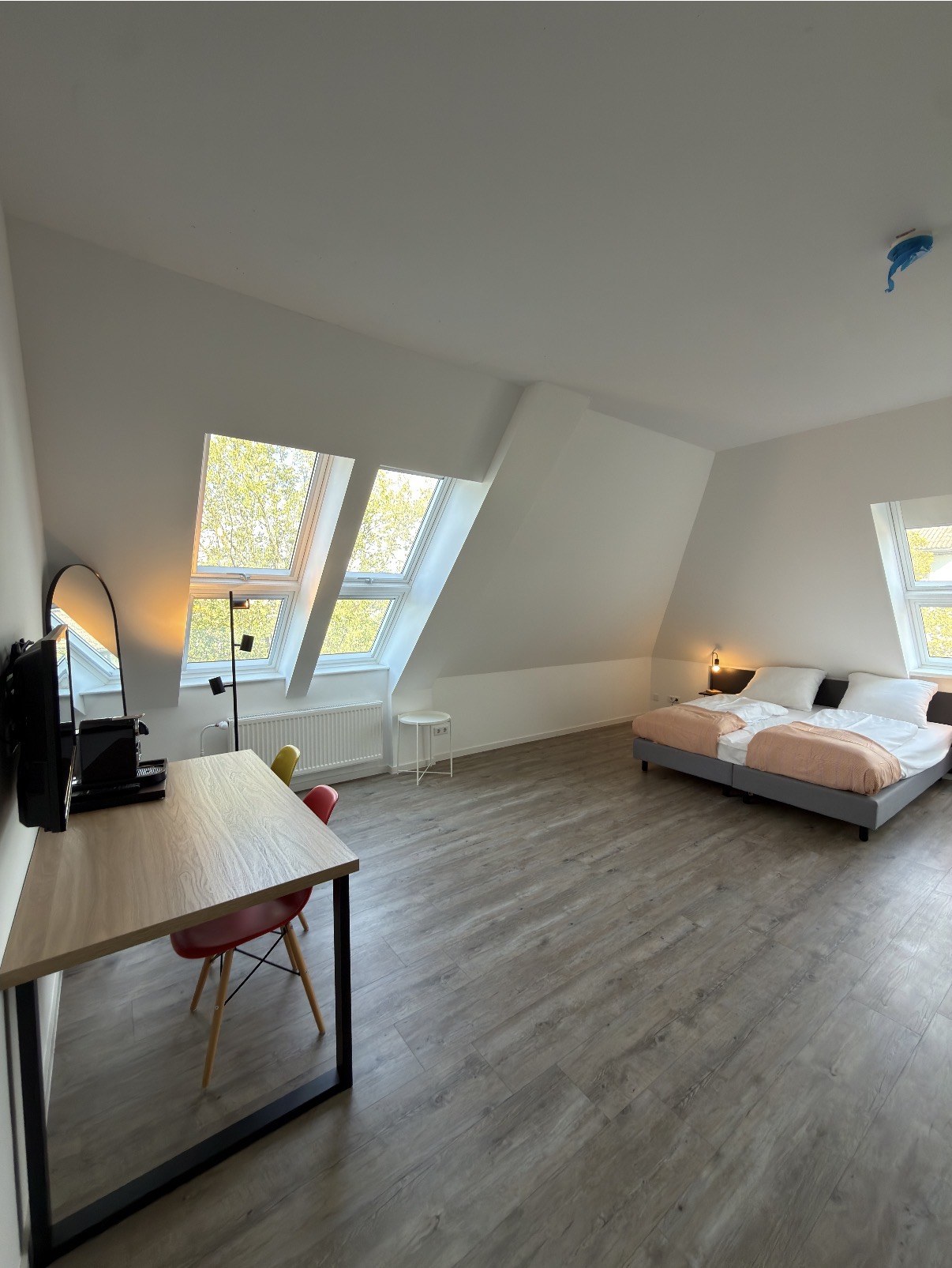 Wohn- und Schlafbereich mit Doppelbett, Schreibtisch und Dachfenstern