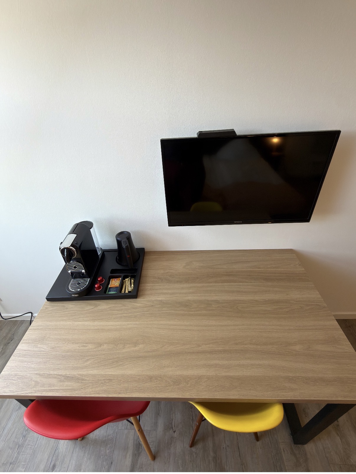 Arbeitstisch mit Kaffeemaschine, Wasserkocher und Wand-TV
